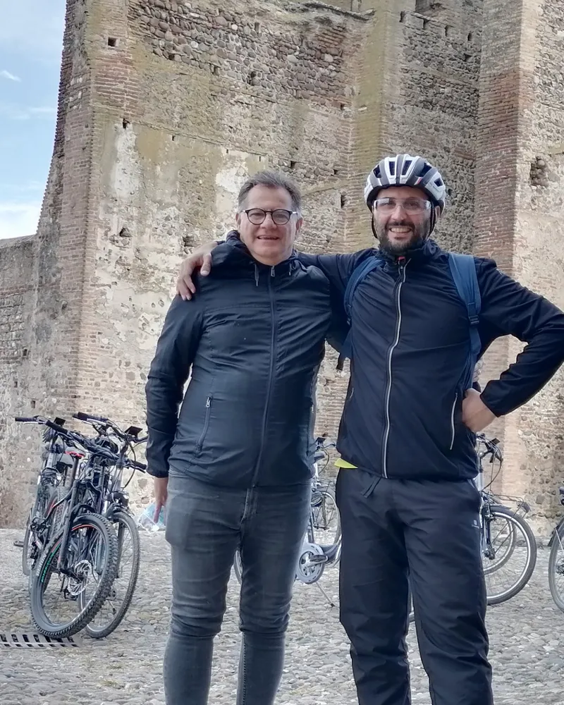 Ritratto della guida con un cliente davanti alla torre di Borghetto
